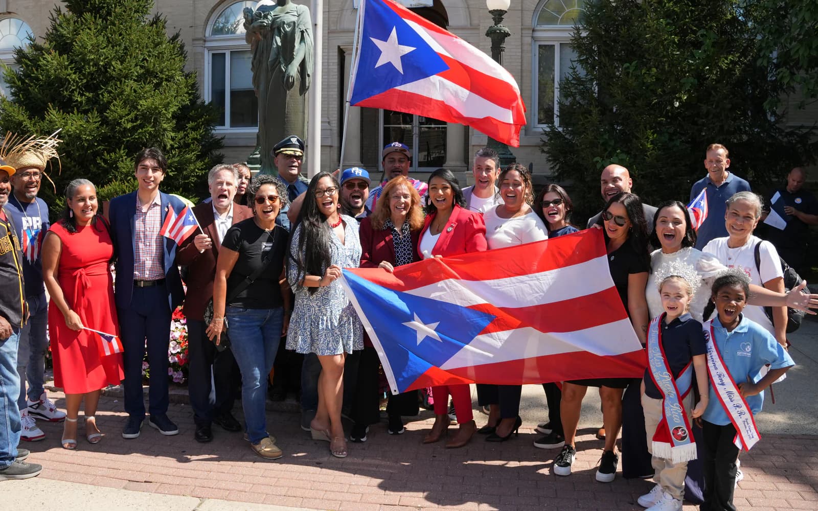 Neighbors gather for a group photo with Puerto Rican flags.